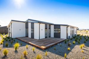 una casa en el desierto con una terraza de madera en Tekapo Top 1000 Apartment en Lake Tekapo