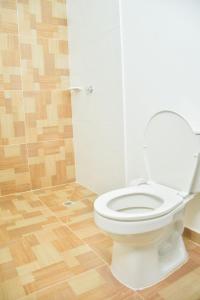 a bathroom with a white toilet and a wooden floor at Hotel Daniels in Fonseca