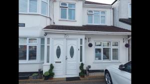 a white house with a white door and windows at Room in Guest room - Family room with private bathroom in Edgware