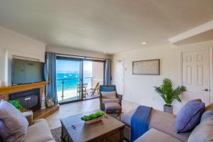 a living room with a fireplace and a view of the ocean at Cohasset Getaway Unit #3 in San Diego