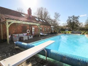 a swimming pool in front of a house at Pool Cottage in Lincoln