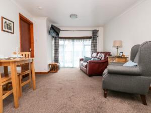 ein Wohnzimmer mit Sessel und Couch in der Unterkunft Coach House Cottage in Bude