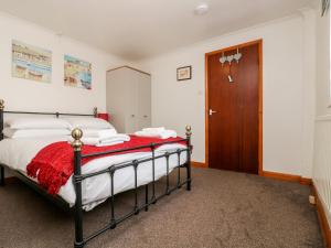 Schlafzimmer mit einem Bett und einer Holztür in der Unterkunft Coach House Cottage in Bude