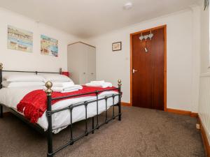 a bedroom with a bed and a wooden door at Coach House Cottage in Bude