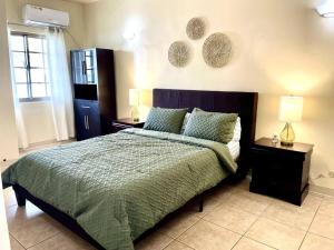 um quarto com uma cama com duas mesas de cabeceira e dois candeeiros em beautiful 4 bedroom tumon house em Tamuning