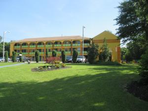 a large yellow building with a large lawn in front of it at Plum Tree Inn in Williamstown