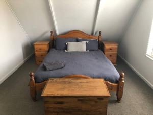 een slaapkamer met een houten bed en een houten tafel bij Dunsborough Beach Shack in Dunsborough