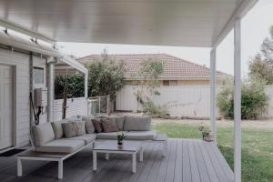 un sofá blanco en un patio con mesa en Dunsborough Beach Shack en Dunsborough