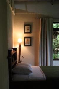 a bedroom with a bed with a lamp and a window at Casa Zu in San Pedro
