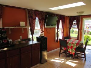 een keuken met een tafel en een tv aan de muur bij Plum Tree Inn in Williamstown