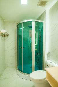 y baño con ducha de cristal y aseo. en Khách sạn Hoa Đông, en Châu Cầu