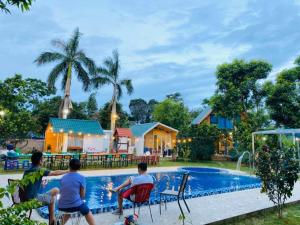 a group of people sitting around a swimming pool at Sunny Home Ba Vì - Venue Travel in Hanoi