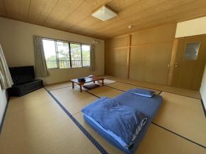 um quarto com uma cama e uma mesa em 大砂荘 OZUNA CAMP and LODGE em Kaiyo