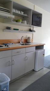 a kitchen with white cabinets and a sink and a microwave at Alpine Chalets in National Park