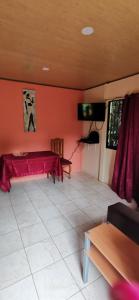 a living room with a red wall and a tv at Starfish Cahuita's House - Casa Vacacional in Cahuita