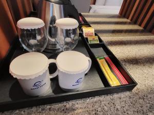 a tray with three cups and glasses and books at Hotel Tour Incheon Airport Hotel & Suites in Incheon