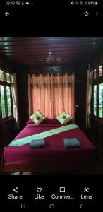a bedroom with a bed with purple sheets and windows at Thai authentic wooden house at Kata in Kata Beach