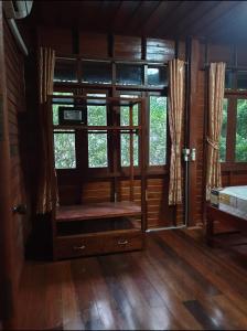 Thai authentic wooden house at Kata في شاطئ كاتا: غرفة مع نافذة في كابينة خشب