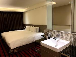een hotelkamer met een bed en een wastafel bij de rěve Express Hotel in Chiayi City