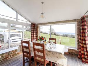a dining room with a table and chairs and windows at Sewin Cottage in Carmarthen