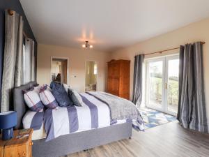 1 dormitorio con cama y ventana grande en Sewin Cottage en Carmarthen