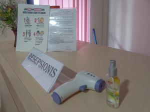 a table with a wii remote control and a bottle of weapons at Homestay Singgasana Mitra RedDoorz in Girian