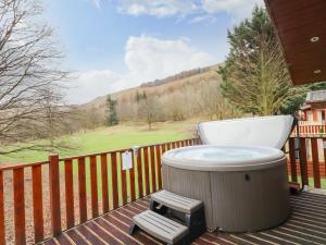 uma banheira de hidromassagem sentada no deque de uma casa em Wainwright Lodge em Windermere