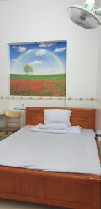 a bedroom with a bed with a painting on the wall at NHÀ NGHỈ THIÊN HƯƠNG in Xa Thang Nhut +18 photos
