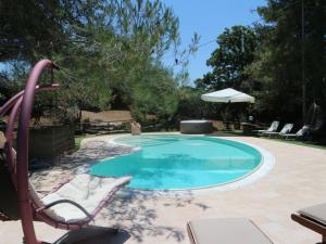 - une piscine avec une chaise et un parasol dans l'établissement Belvilla by OYO Villa Max, à Suvereto
