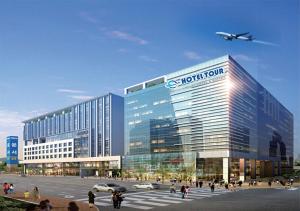 a large office building with a plane flying over it at Hotel Tour Incheon Airport Hotel & Suites in Incheon