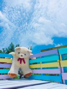 a stuffed teddy bear is sitting on a bench at 與大自然融合的包棟小屋 in Hengchun