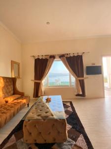 a living room with a couch and a large window at Gandhara castle hotel Resort & Adventure Club in Khanpur