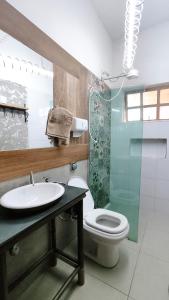 uma casa de banho com um WC, um lavatório e um chuveiro em Pousada Mundo Consciente em Piumhi