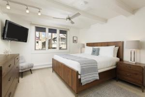 1 dormitorio con 1 cama y TV de pantalla plana en Chateau Snow Unit 202, Renovated Condo with Great Natural Light, Excellent Location, en Aspen