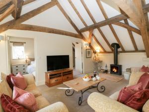 a living room with a tv and a fireplace at The Coach House15 in Warminster