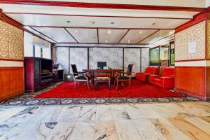 uma sala de estar com uma mesa e um sofá em OYO 119 Le Vondome em Manama