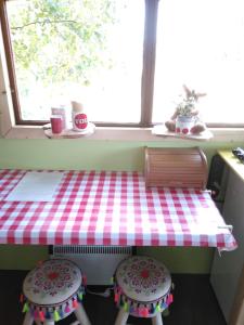 uma mesa e dois bancos numa cozinha com uma janela em De Balkende Hoeve em Aarschot
