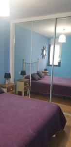 a bedroom with two beds and a mirror at Apartamentos Atlanterra COSTA Y SOL in Zahara de los Atunes