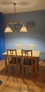 a wooden table with two chairs and two lights at Apartamentos Atlanterra COSTA Y SOL in Zahara de los Atunes