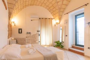una camera con un grande letto e una grande finestra di Leondari Rooms a Otranto