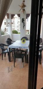 a dining table and chairs in a room with a ceiling at Apartamentos Atlanterra COSTA Y SOL in Zahara de los Atunes
