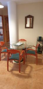 a dining room with a glass table and chairs at Apartamentos Atlanterra COSTA Y SOL in Zahara de los Atunes