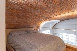 una camera da letto con un muro di mattoni e un letto di La Baby a Torino