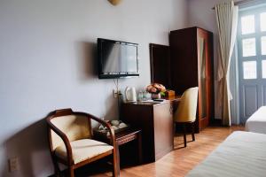 sypialnia z biurkiem i telewizorem na ścianie w obiekcie Rembrandt Hotel Nha Trang w mieście Nha Trang