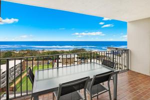 a dining room table with a balcony overlooking the ocean at Majorca Isle Beachside Resort in Maroochydore