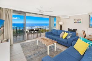 a living room filled with furniture and a blue couch at Majorca Isle Beachside Resort in Maroochydore