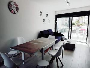 a living room with a wooden table and chairs at Le petit nid de Xanie in Orihuela Costa