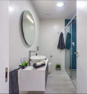 a white bathroom with a sink and a mirror at Le petit nid de Xanie in Orihuela