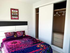 um quarto com uma cama roxa e um closet em Le petit nid de Xanie em Orihuela