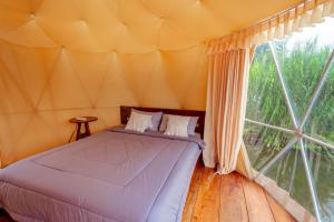 a bed in a tent with a large window at Jempana View in Kintamani